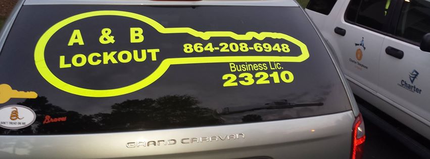 Our van's rear window, with a yellow key outline and our phone number